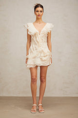 A short pink dress with multiple layered ruffles and floral embellishments inspired by faux flowers