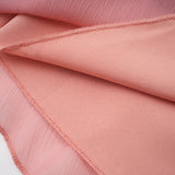 A short pink halterneck dress with tiered layers and a mini length skirt