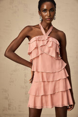 A short pink halterneck dress with tiered layers and a mini length skirt