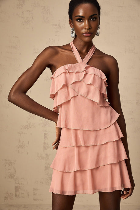 A short pink halterneck dress with tiered layers and a mini length skirt