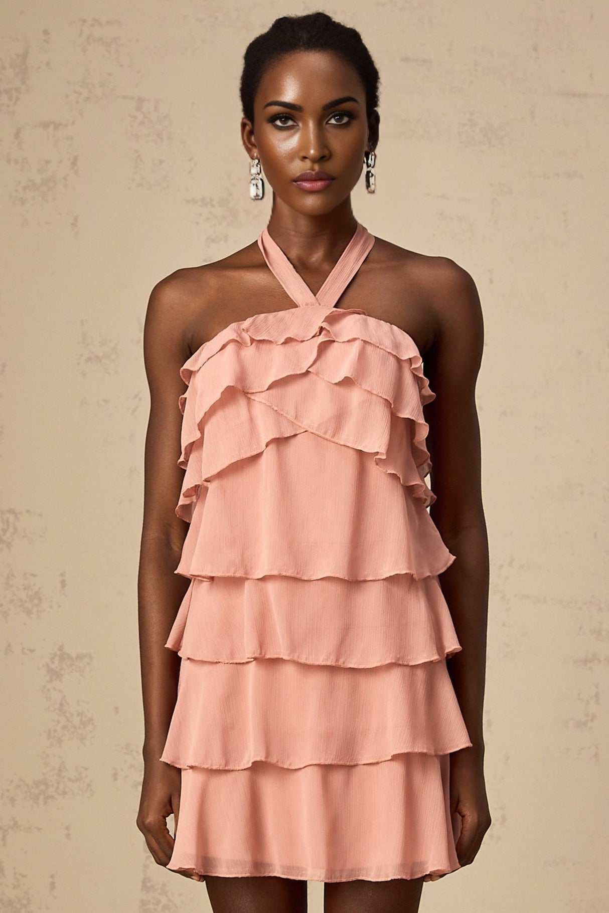 A short pink halterneck dress with tiered ruffles and a mini length skirt