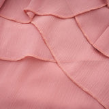 A short pink halterneck dress with tiered ruffles and a mini length skirt