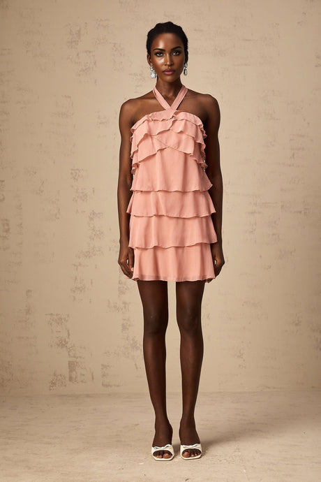 A short pink halterneck dress with tiered ruffles and a mini length skirt