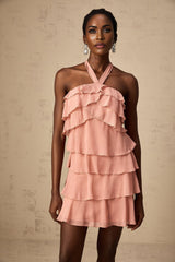 A short pink halterneck dress with tiered ruffles and a mini length skirt