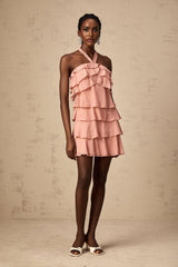 A short pink mini dress with a halter neckline and tiered layers in a soft briar rose color