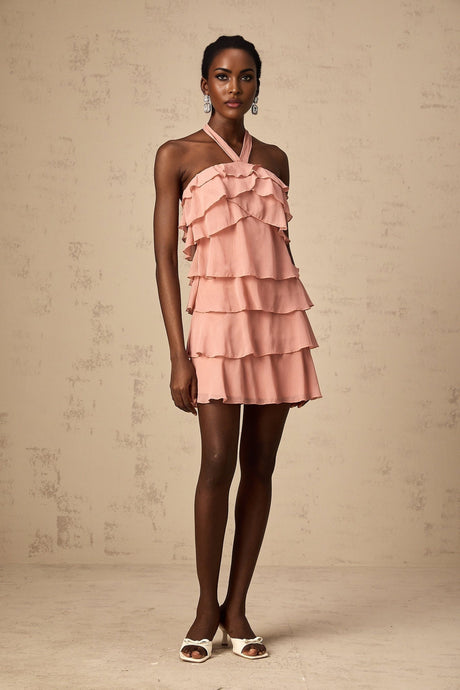 A short pink mini dress with a halter neckline and tiered layers in a soft briar rose color