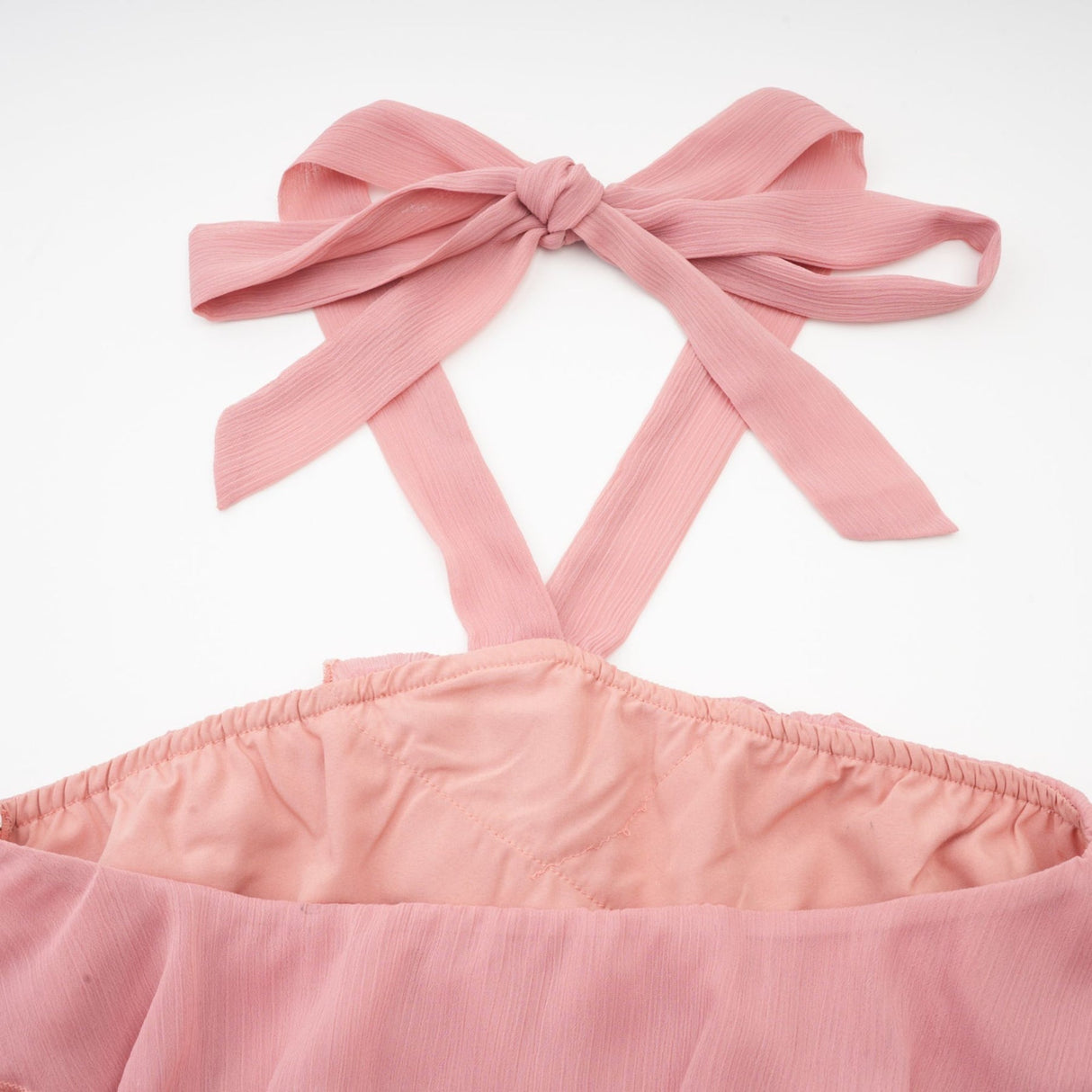 A short pink mini dress with a halter neckline and tiered skirt design in a briar rose shade