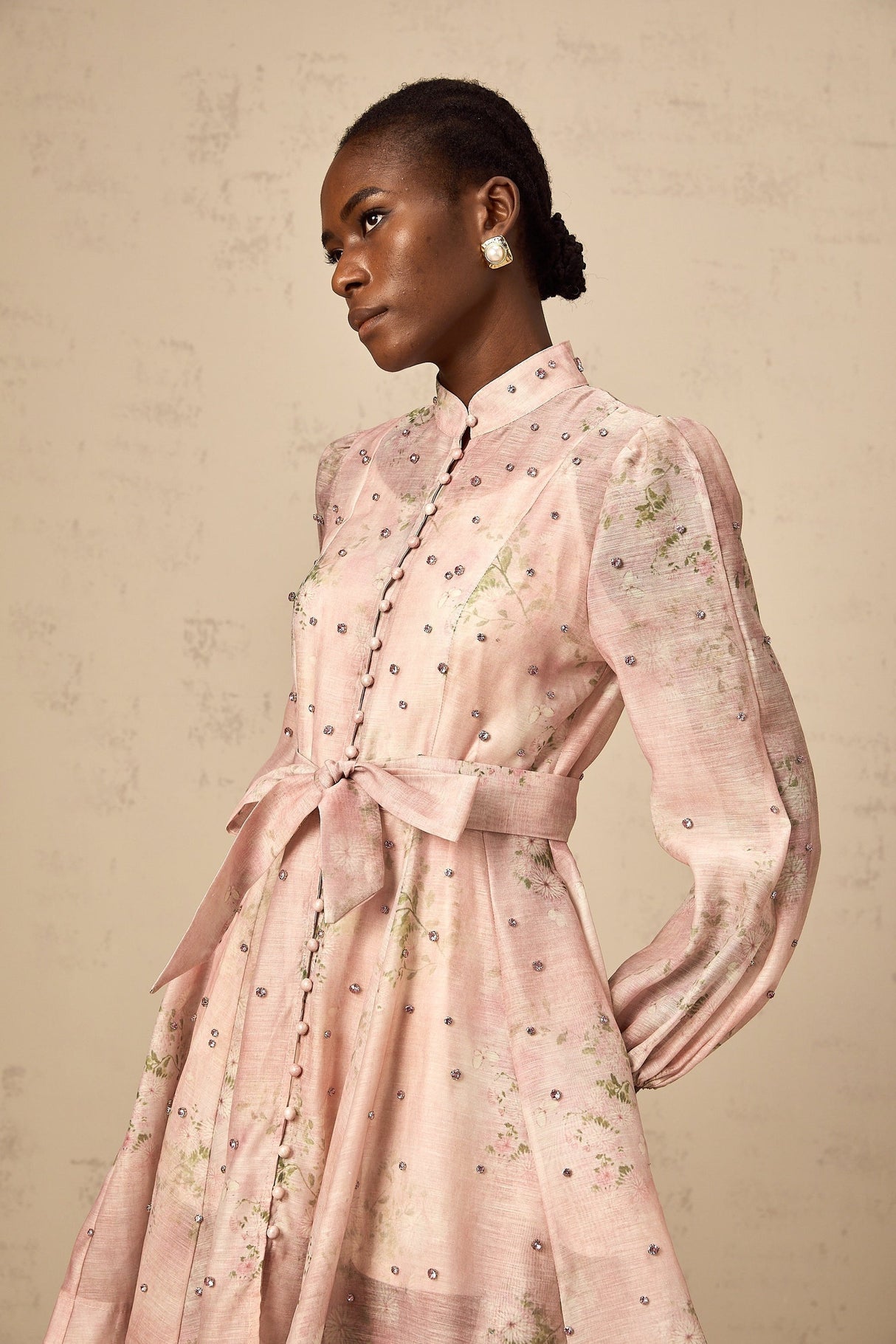 A short pink mini dress with floral print and embellishments featuring a narcissus flower design