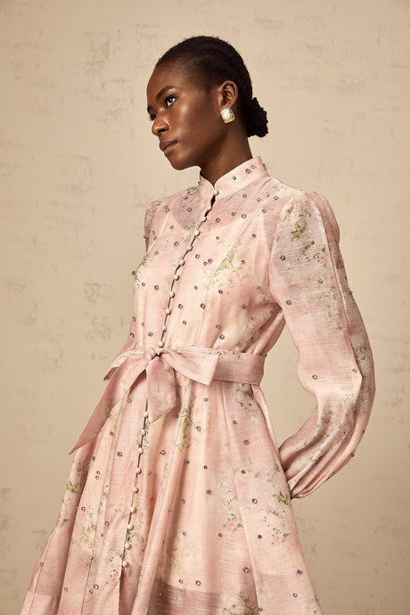 A short pink mini dress with floral print and embellishments featuring a narcissus flower design