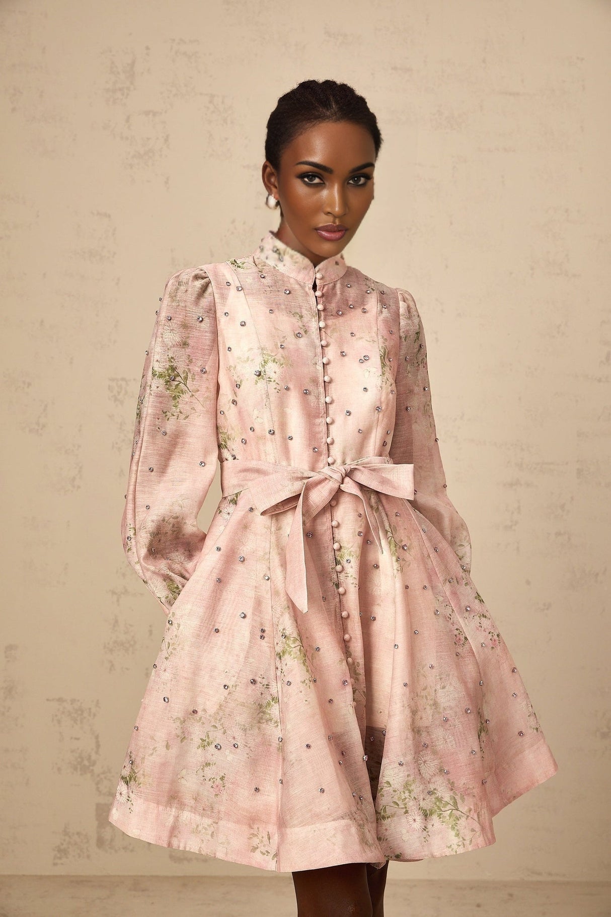 A short pink mini dress with floral print pattern and embellished details featuring a narcisse design