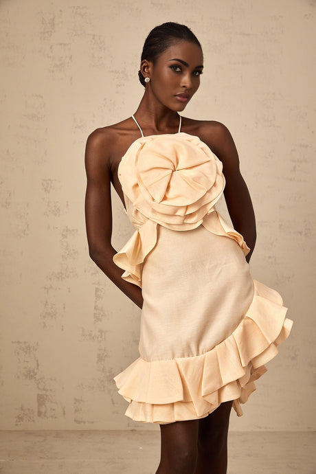 A short pink mini dress with threedimensional petallike ruffles covering the bodice and skirt creating a floral inspired texture and volume