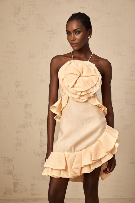 A short pink mini dress with threedimensional ruffled petal details covering the entire garment creating a floral inspired texture and silhouette