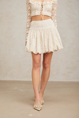 A short pleated mini skirt with shimmering sequins covering the fabric creating a sparkly and festive appearance