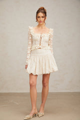 A short pleated mini skirt with sparkling sequins covering the fabric named Tiphaine