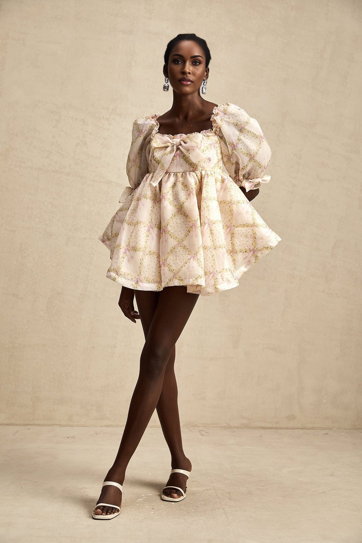 A short puffy mini dress with a checkered pattern featuring a large bow detail