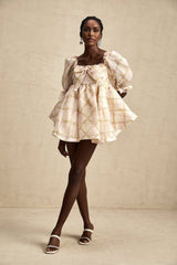 A short puffy mini dress with a checkered pattern featuring a large bow detail