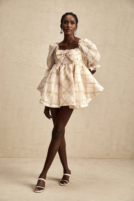 A short puffy mini dress with a checkered pattern featuring a large bow detail