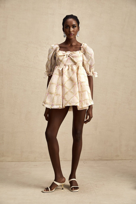 A short puffy mini dress with a checkered pattern featuring a prominent bow detail