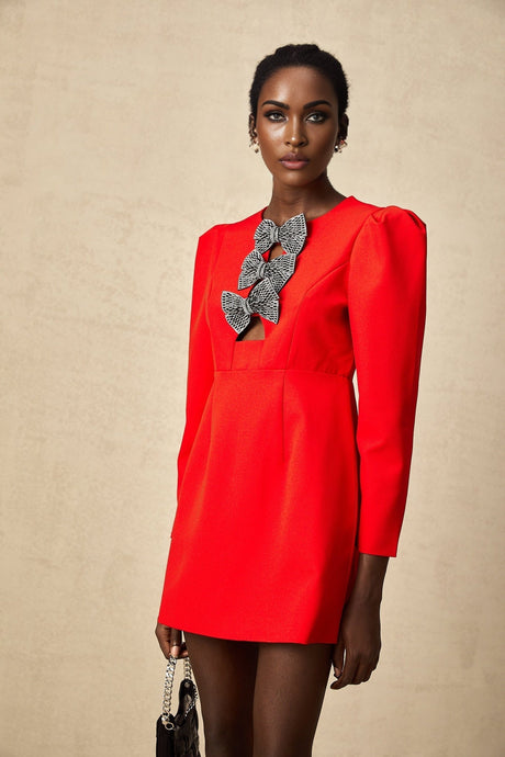 A short red mini dress with a split skirt featuring a decorative studded bow accent