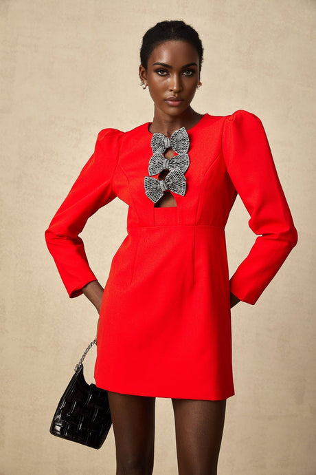 A short red mini dress with a split skirt featuring decorative studs and a bow detail