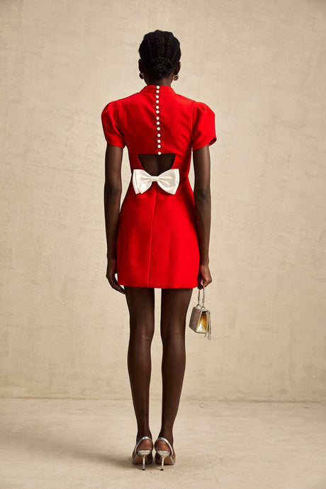 A short red mini dress with petal sleeves featuring a cut out design and bow detail