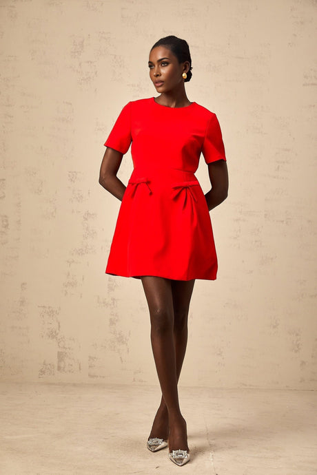 A short red mini dress with short sleeves and a decorative bow detail