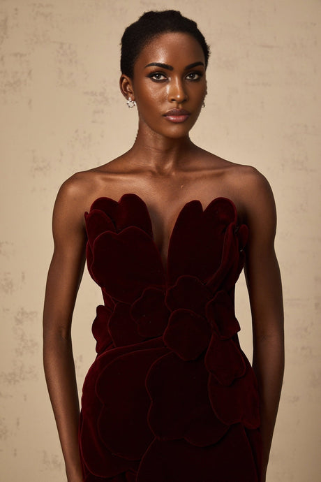 A short red velvet mini dress with floral appliques adorning the fabric