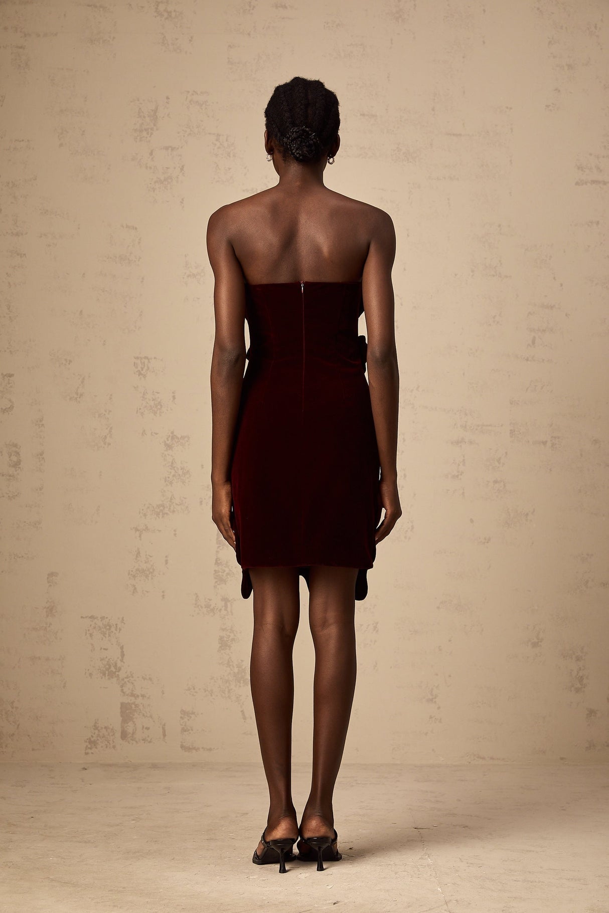 A short red velvet mini dress with floral appliques adorning the fabric