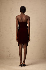 A short red velvet mini dress with floral appliques adorning the fabric