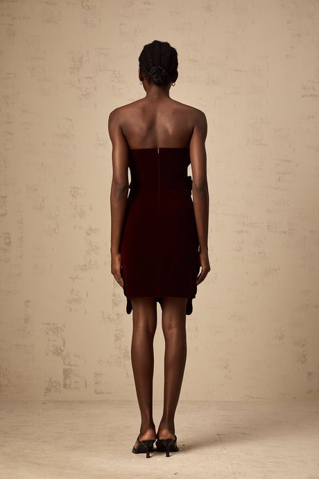 A short red velvet mini dress with floral appliques adorning the fabric