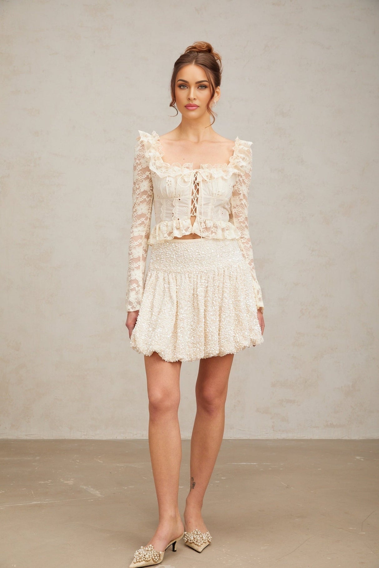 A short shimmering mini skirt with pleats and allover sequin embellishment in a metallic finish