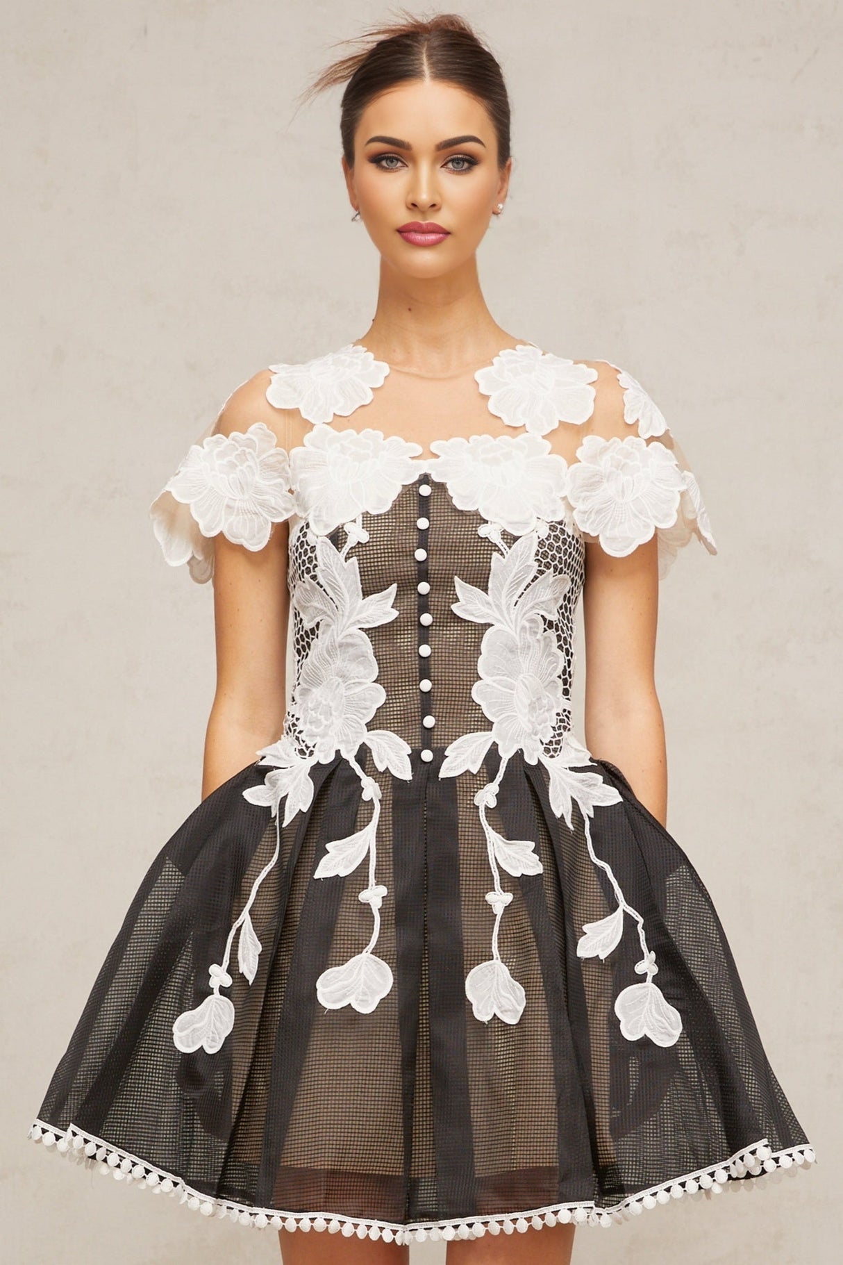 A short sleeveless dress with colorblocked sections and floral embroidery details featuring a mini length and feminine silhouette