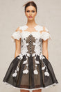 A short sleeveless dress with colorblocked sections and floral embroidery details featuring a mini length and feminine silhouette