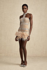 A short sleeveless mini dress adorned with crystal embellishments and featuring feather trim along the hemline