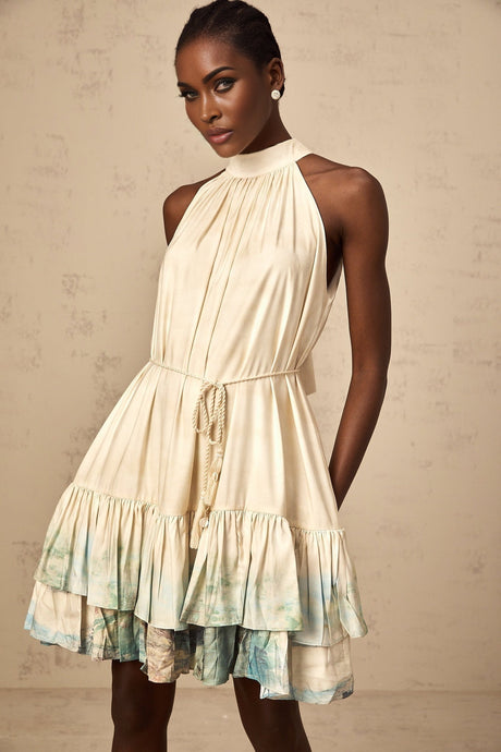 A short sleeveless mini dress with a layered design featuring a pattern print in multiple colors and a flowy silhouette
