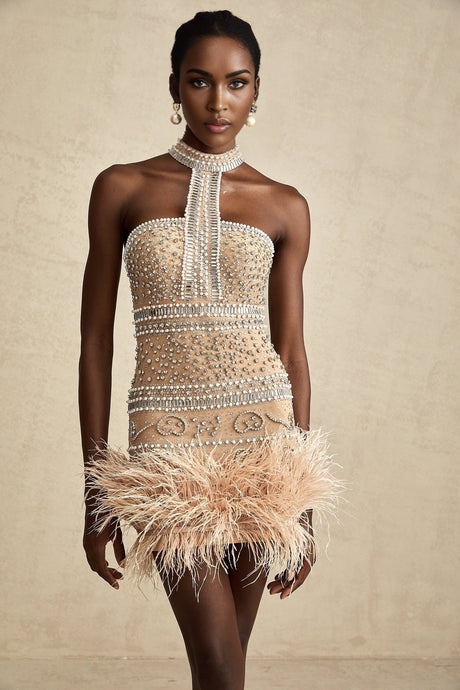 A short sleeveless mini dress with crystal embellishments and feather trim along the hemline
