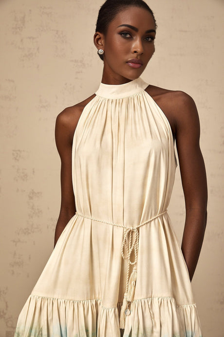 A short sleeveless mini dress with multiple layered tiers featuring a mixed pattern print in various colors