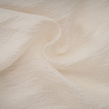 A short sleeveless neutral colored mini dress with tiered layers and delicate floral appliques scattered throughout