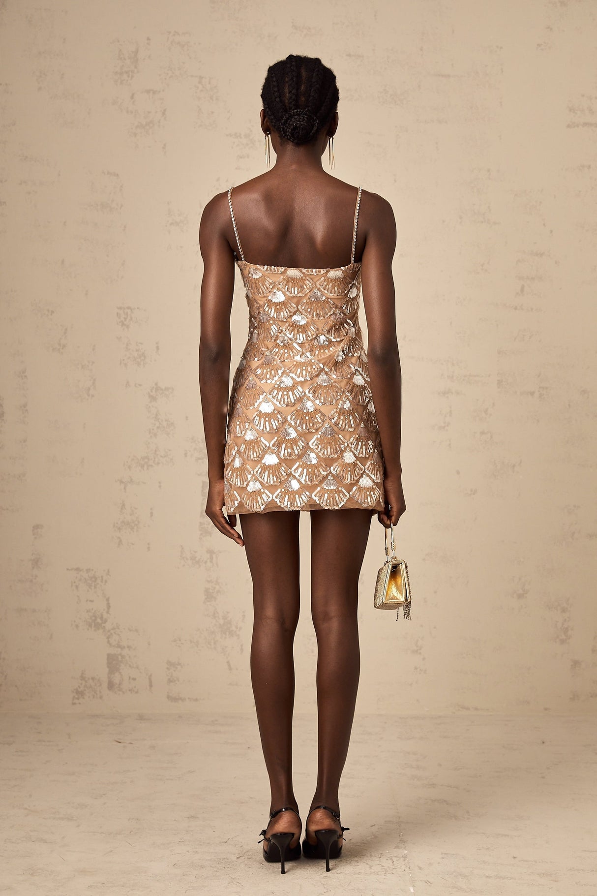 A short sparkling mini dress with sequin embellishments covering the fabric creating a shimmering effect elegant party attire with a festive and glamorous appearance