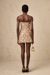 A short sparkling mini dress with sequin embellishments covering the fabric creating a shimmering effect elegant party attire with a festive and glamorous appearance