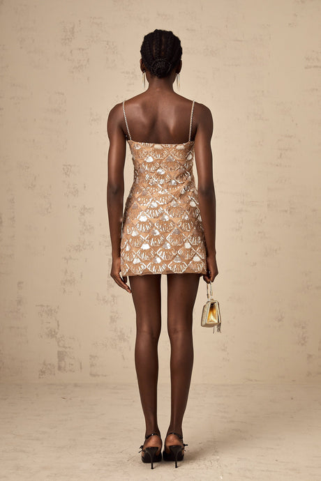 A short sparkling mini dress with sequin embellishments covering the fabric creating a shimmering effect elegant party attire with a festive and glamorous appearance