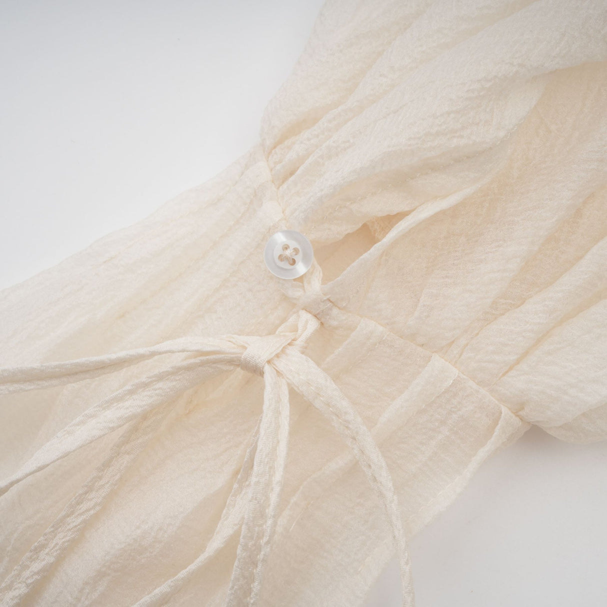 A short tiered mini dress in neutral tones featuring delicate floral appliques named Zephyrine