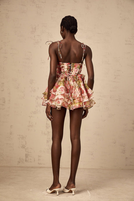 A short tiered mini dress with a strawberry print pattern featuring a light background and red strawberries scattered throughout the fabric