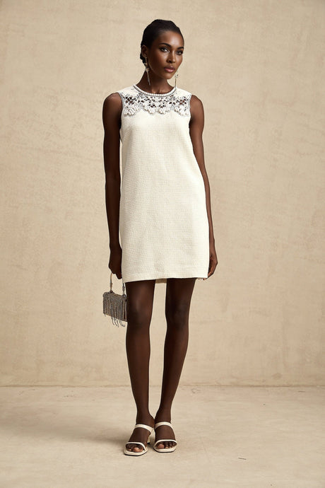 A short tweed mini dress with embroidery details and cut out sections featuring a feminine silhouette in a classic style