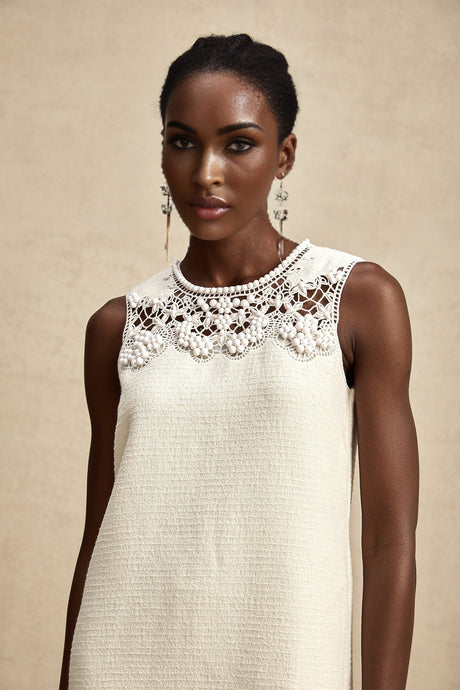 A short tweed mini dress with embroidery details and cut out sections worn by a model