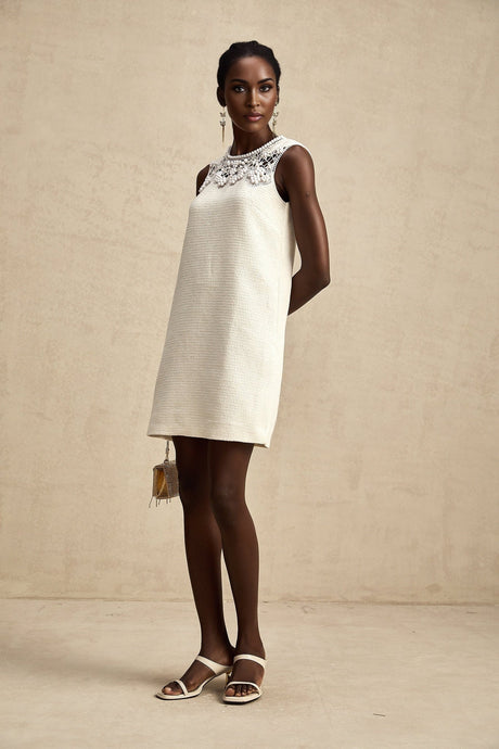 A short tweed mini dress with embroidery details and cutout sections featuring a feminine silhouette and textured fabric