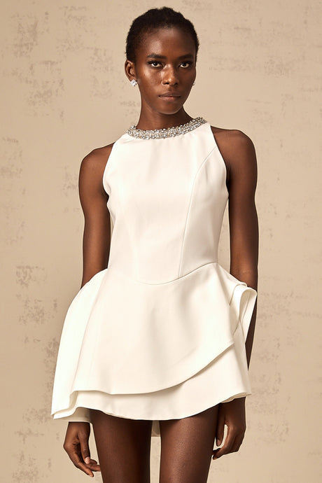 A short white crystalembellished mini dress with layered design worn by a female model