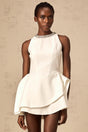 A short white crystalembellished mini dress with layered design worn by a female model