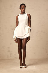 A short white crystalembellished mini dress with layered skirt featuring a sleeveless design and formfitting silhouette