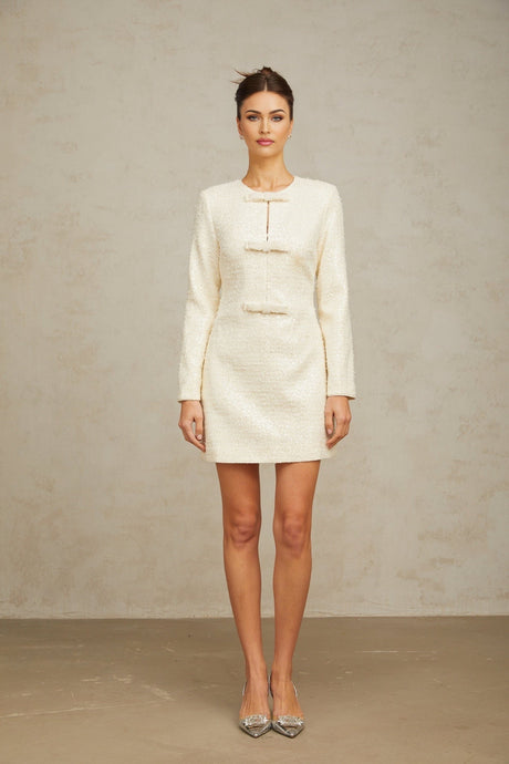 A short white dress made of tweed fabric embellished with sparkling sequins featuring a classic mini length design